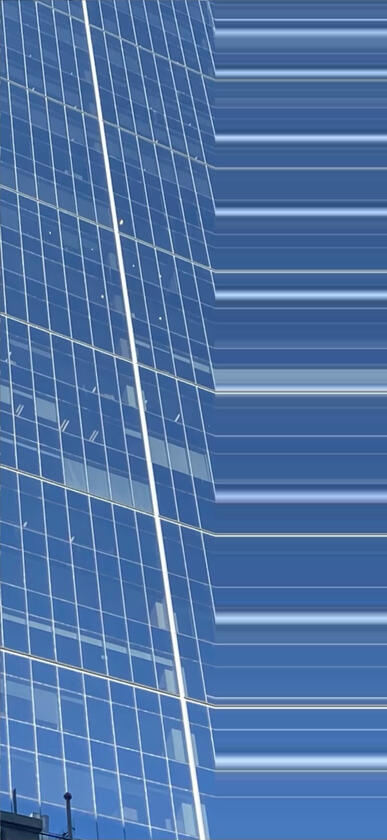 Photograph of reflective solar panels on a building facade, distorted with vertical scanlines.
